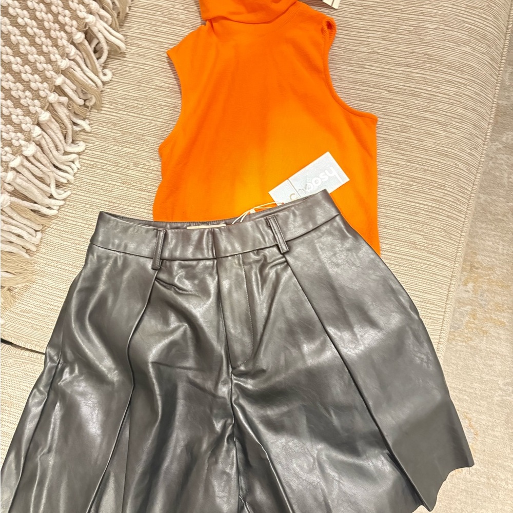 Faux leather shorts and orange top set.